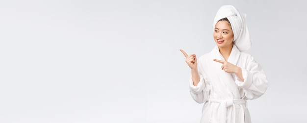 Beauty portrait of young woman showing and pointing finger to empty copy space asian beauty in bathrobe