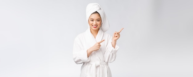 Beauty portrait of young woman showing and pointing finger to empty copy space asian beauty in bathrobe