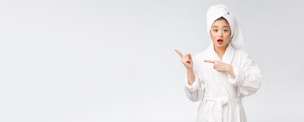 Beauty portrait of young woman showing and pointing finger to empty copy space asian beauty in bathrobe