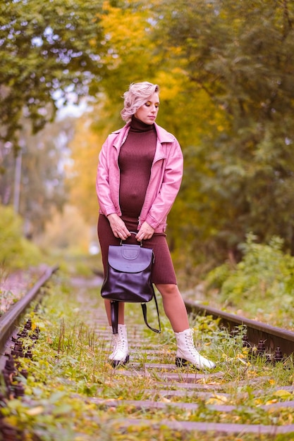 Foto bella ragazza incinta che cammina sulla ferrovia