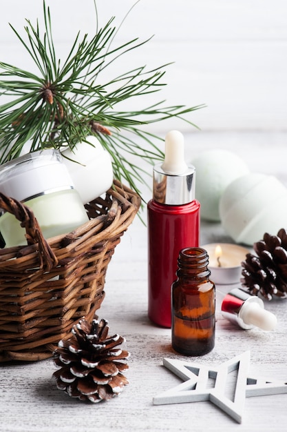 Beauty product in basket in Christmas SPA composition with pine tree branches and stars, lit candle