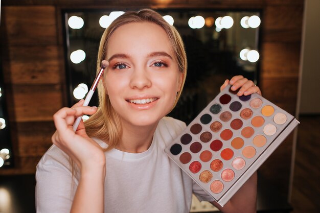 Beauty room. Cheerful nice young woman look on camera and smile.