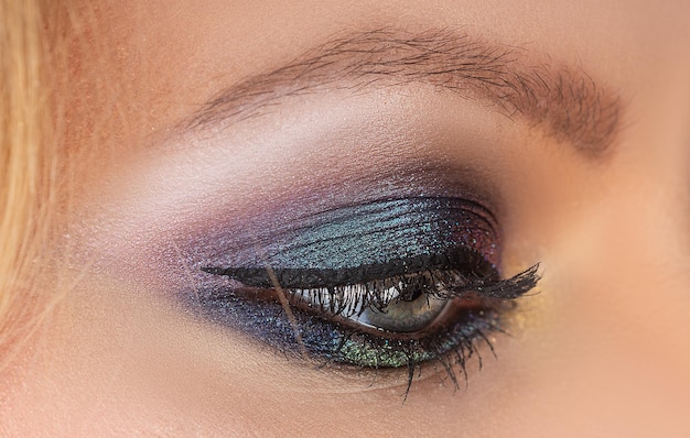 Beauty salon female eye with bright makeup visage cosmetics\
smokey eyes