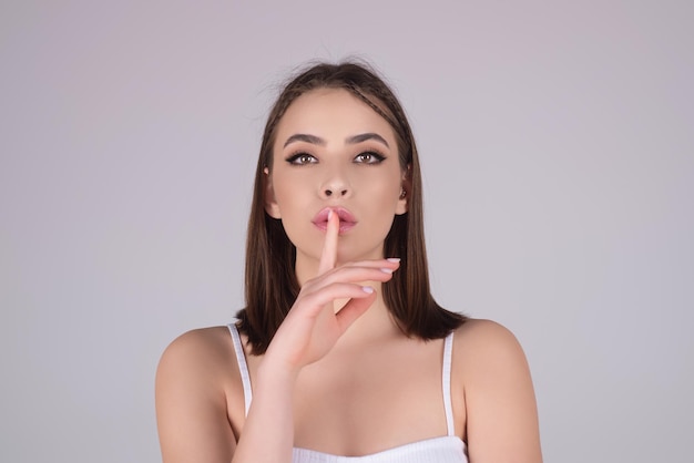 美しさと沈黙の概念のポートレート、魅力的な面白い若い女性が、fing で shhh タブーサインを示しています