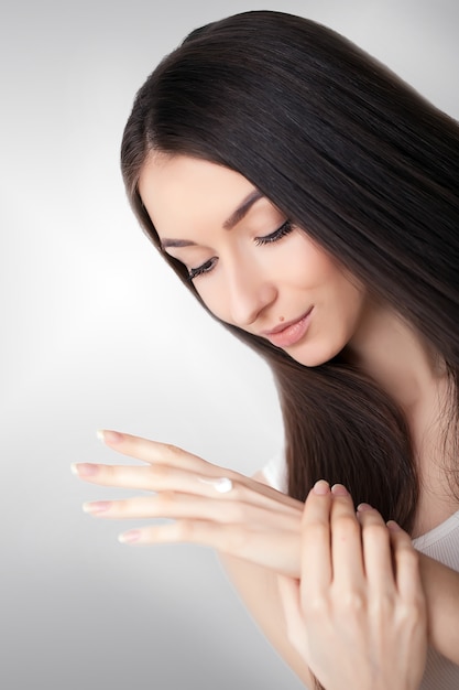 Beauty Skin Care. Beautiful Woman Applying Cosmetic Face Cream