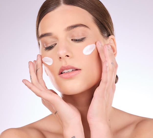 beauty skincare or girl with face cream product in daily grooming treatment with makeup cosmetics in studio dermatology mockup space background or female model applying facial sunscreen lotion