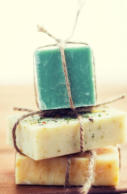 beauty, spa, body care, bath and natural cosmetics concept - close up of handmade soap bars on wooden table