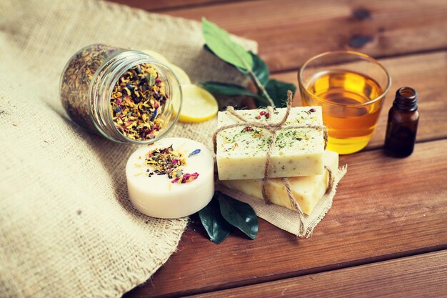 beauty, spa, body care, natural cosmetics and wellness concept - close up of handmade soap bars on wooden table