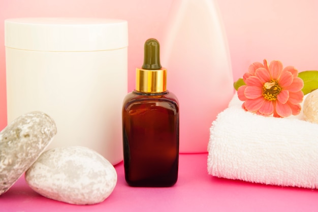 Cosmetici di bellezza spa, terapia del salone. bottiglia di vetro sul rosa.