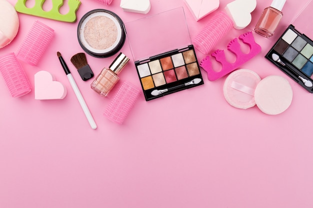 Beauty Spa Feminine Concept. Different Make Up Beauty Care Essentials Cosmetics on Flat Lay Pink Background. Top View. Above.