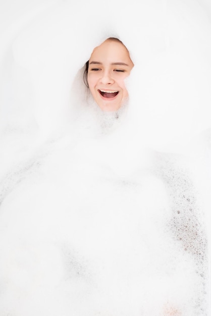 Beauty spa personal care Girl relaxes in the bathroom with foam has fun