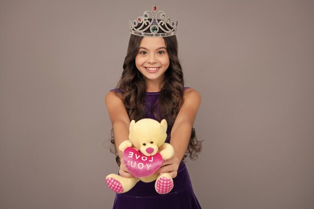 Красавица-подросток-королева носит корону Ребенок в принцесской диадеме Счастливая девушка с положительными и улыбающимися эмоциями