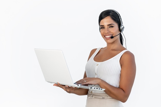 Beauty telemarketer standing while working and smiling to the camera in a white background