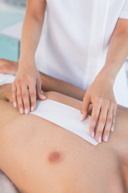 Beauty therapist waxing mans chest