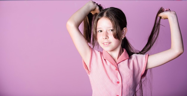 Beauty tips for tidy hair Innocence concept Happy childrens day Pure beauty Girl long healthy shiny hair close up Little girl with long hair Kid cute face with adorable hair on pink background
