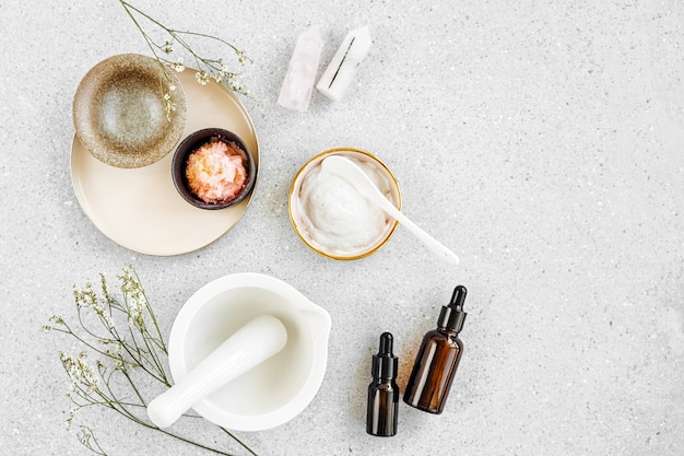 Photo beauty treatment ingredients for making homemade skin care cosmetic mask. various bowl with clay, cream, essential oil and natural ingredients  on white table background. organic spa cosmetic products