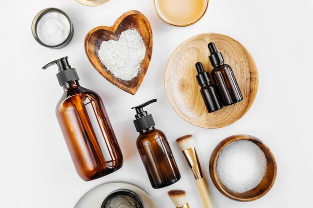 beauty treatment ingredients for making homemade skin care cosmetic mask. various bowl with clay, cream, essential oil and natural ingredients  on white table background. organic spa cosmetic products
