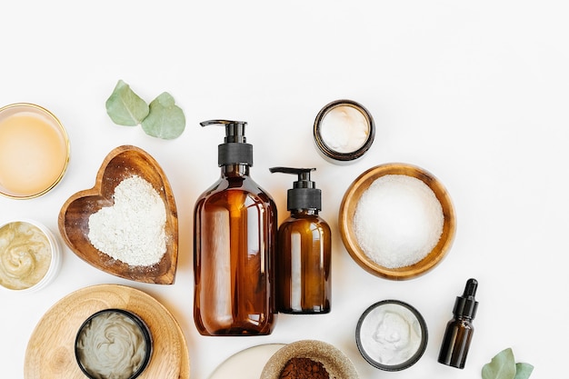 beauty treatment ingredients for making homemade skin care cosmetic mask. various bowl with clay, cream, essential oil and natural ingredients  on white table background. organic spa cosmetic products