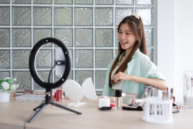 Beauty Vlogger-concept Jonge vrouw lacht terwijl ze video opneemt en introduceert cosmetica op Vlog