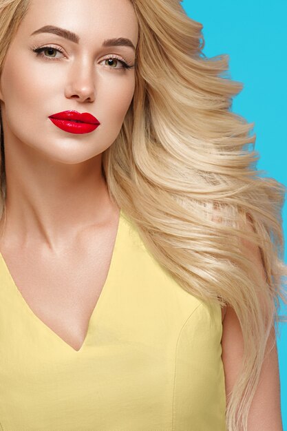 Beauty woman curly blonde hair flower hair manicured nails. Trendy colors blue yellow. Studio shot.