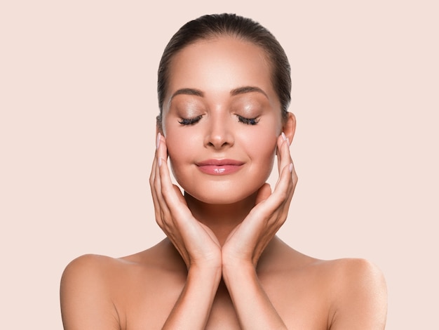 beauty woman healthy skin clean spa manicure nails hands touching face. color background yellow