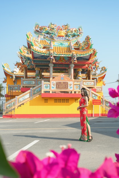 美しさの女性と中国の新年の買い物袋を保持