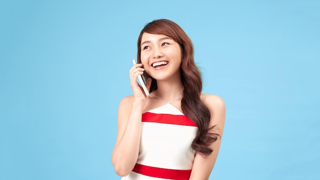 Beauty woman talk on phone isolated on blue background