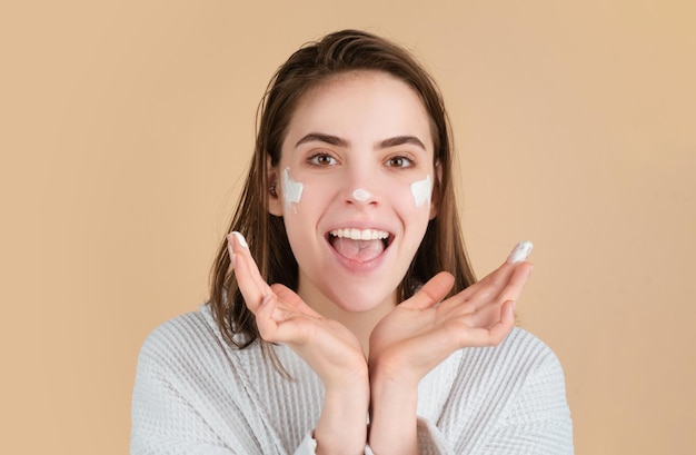 Beauty woman with clean healthy skin natural make up spa concept Beautiful girl applying moisturizer cream on her pretty face