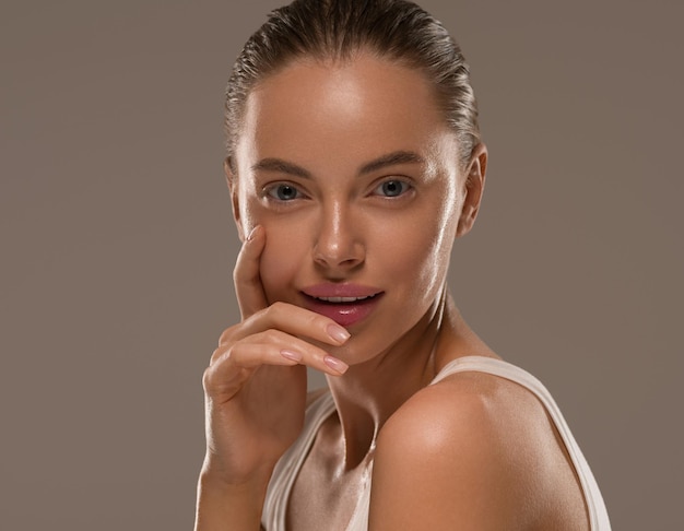 Foto la donna di bellezza con le mani naturali sane compone il fondo pulito di colore di concetto della pelle fresca