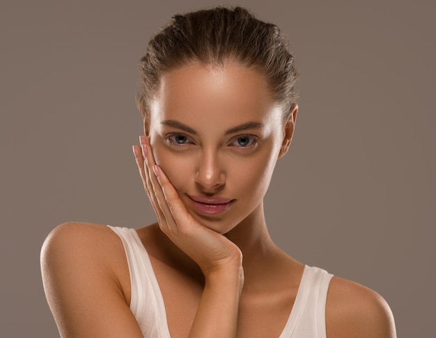 Foto la donna di bellezza con le mani naturali sane compone il fondo pulito di colore di concetto della pelle fresca