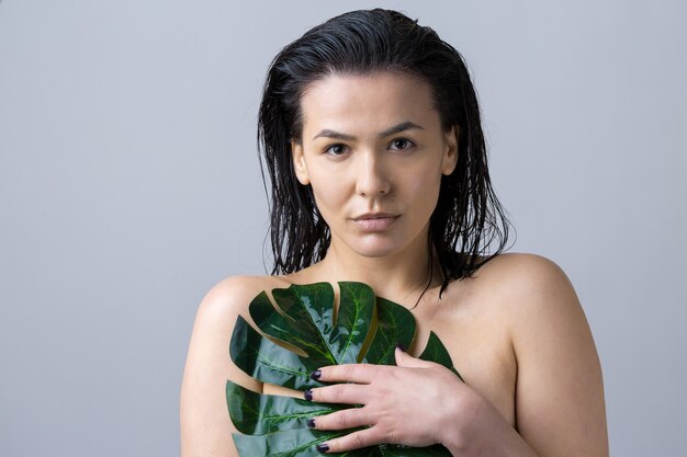 Beauty Woman with natural green palm leaf portrait. Fashion, beauty, make-up, cosmetics.