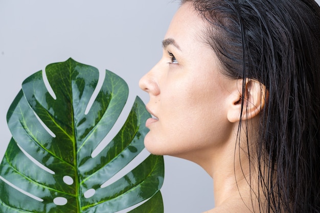 Beauty Woman with natural green palm leaf portrait. Fashion, beauty, make-up, cosmetics.