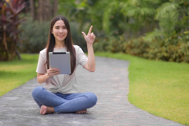 Beauty women hiding tablet happy smile in city park