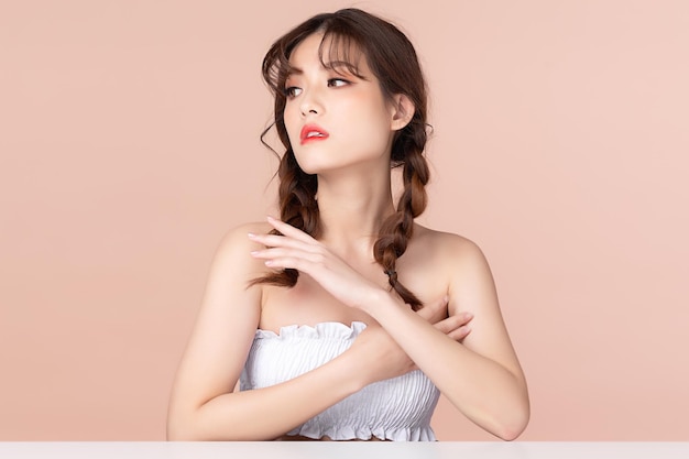 Beauty young asian woman has two pigtails and smiles clean fresh bare skin concept Asian girl beauty face skincare and health wellness Facial treatment Perfect skin Isolated on beige background