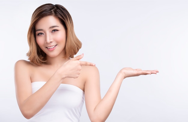 Beauty young asian woman pointing hand for product on white background