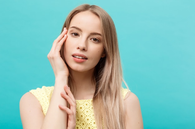 Bellezza giovane indoeuropea modello femminile ragazza toccando il suo viso pelle guance le dita delle mani.