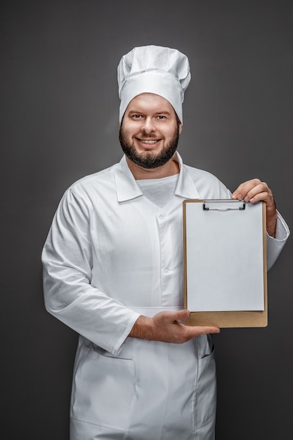 Bebaarde chef-kok met leeg klembord