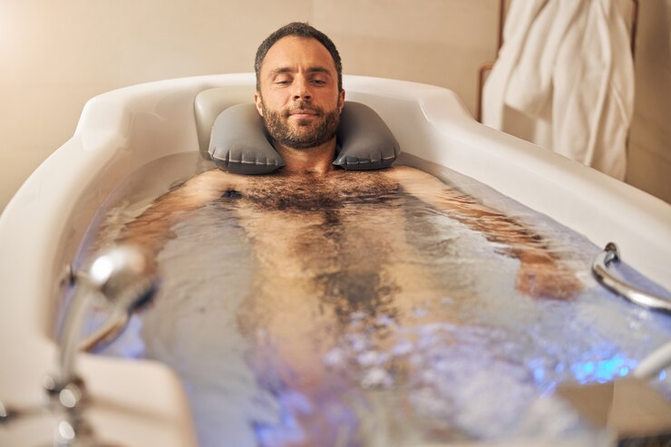 Bebaarde heer die in bad ontspant terwijl hij een hydrotherapieprocedure heeft
