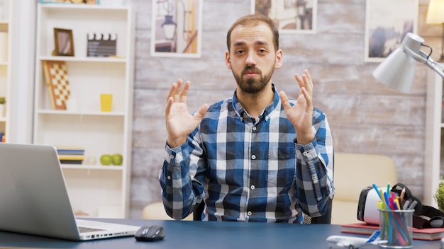 Bebaarde jonge influencer die naar de camera kijkt en de intro maakt voor zijn publiek.