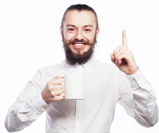 Bebaarde jonge man koffie drinken en duim opdagen.