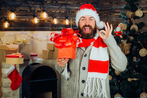 Bebaarde kerstman wenst prettige kerstdagen en gelukkig nieuwjaar Kerstman met kerstcadeaus