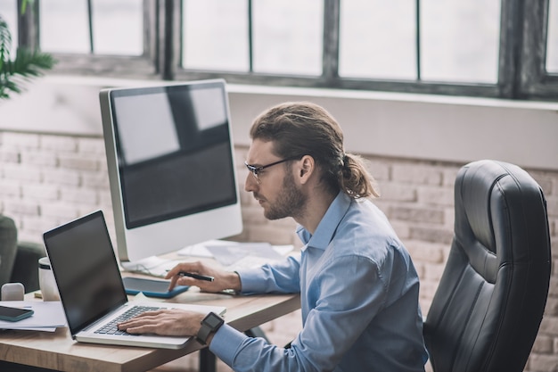 Bebaarde man aan het werk op laptop