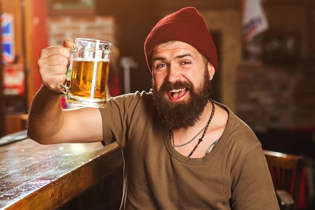 Bebaarde man dronken ontspannen plezier hebben Knappe man ontspannen in pub met bier Alcohol drinken bestellen Alcohol drankjes