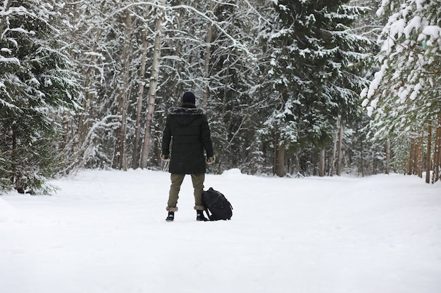 Bebaarde man in het bos van de winter. aantrekkelijke gelukkige jonge man met baard lopen in het park.