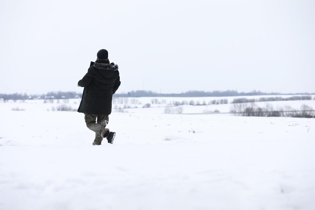 Bebaarde man in het bos van de winter. Aantrekkelijke gelukkige jonge man met baard lopen in het park.