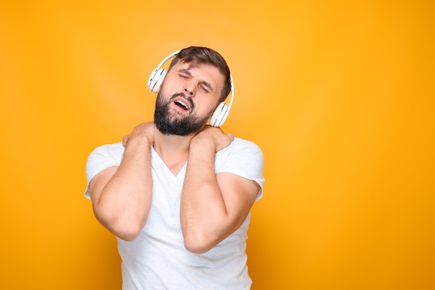 Bebaarde man in koptelefoon voert emotioneel dansbewegingen uit op muziek.