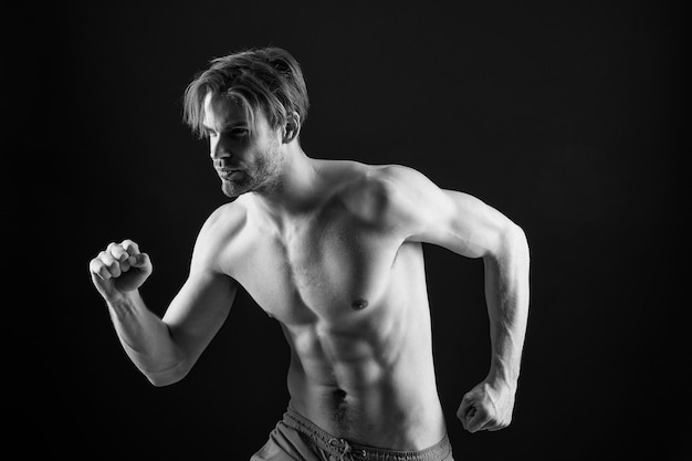 Bebaarde man in lopende positie sport Sexy macho bodybuilder met fit blote lichaam fitness sportman met sixpack spieren sport atleet training met energie en kracht bij training