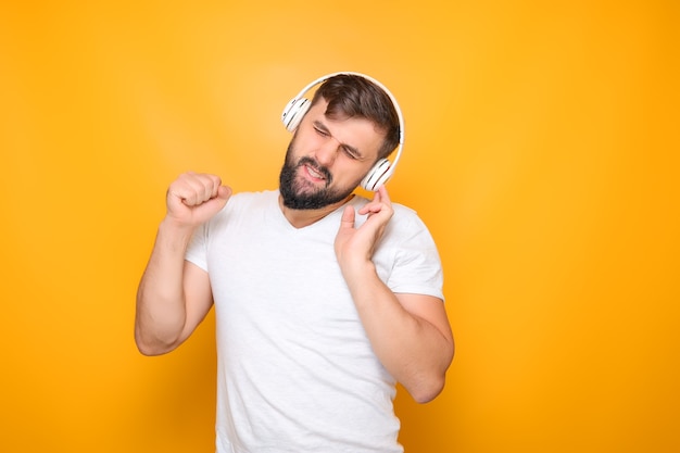 Bebaarde man in muzikale koptelefoon sloot zijn ogen en luistert naar muziek.