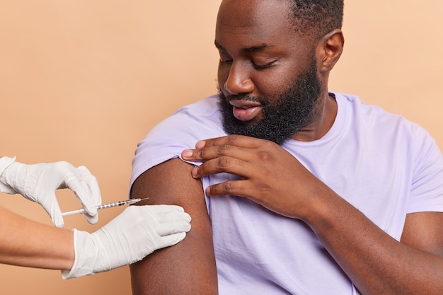 Bebaarde man krijgt covid 19-vaccin in kliniek