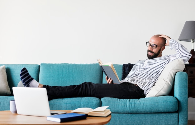 Bebaarde man lezen op de bank